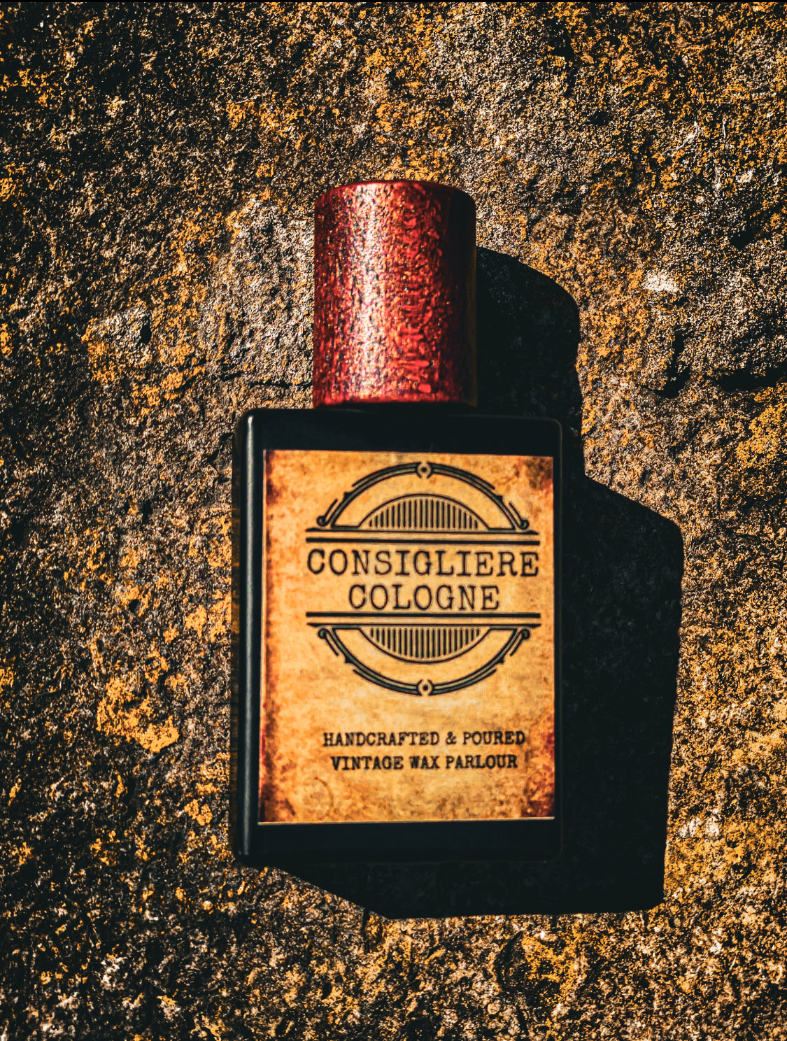 Perfume bottle labeled 'Consigliere Cologne' on a textured stone surface