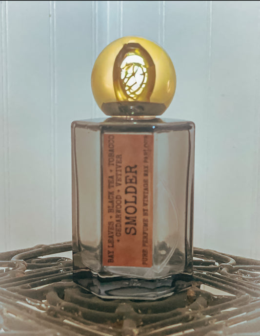 Perfume bottle with gold cap on a textured surface