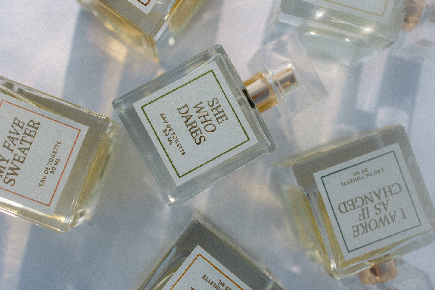 Perfume bottles with labels on a reflective surface