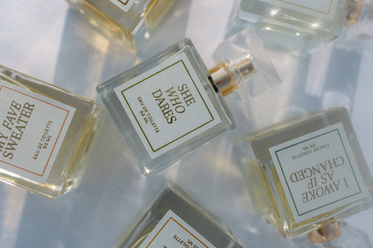 Perfume bottles with labels on a reflective surface