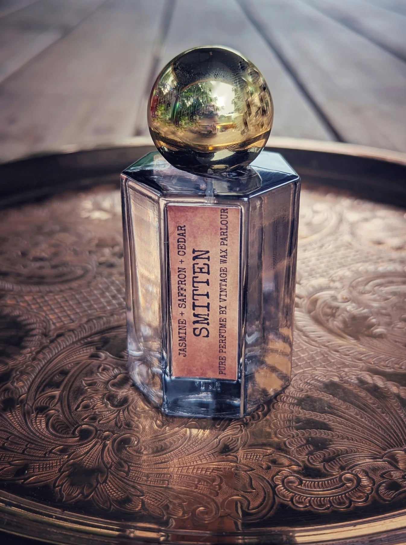 Perfume bottle labeled 'Smitted' on an ornate surface