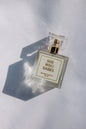 Perfume bottle labeled 'She Who Dares' on a light background