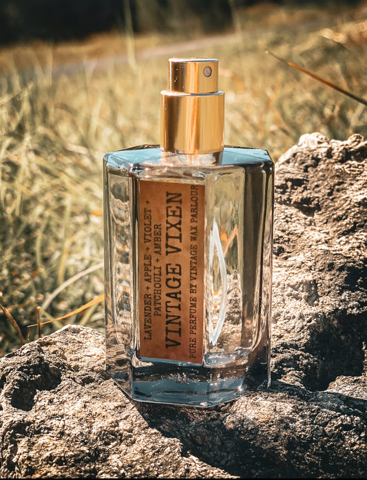 Perfume bottle with gold cap on a rock with a natural background