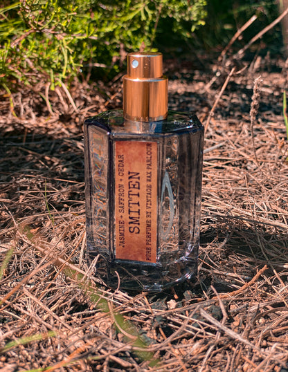 Perfume bottle labeled 'Smitted' on a natural background