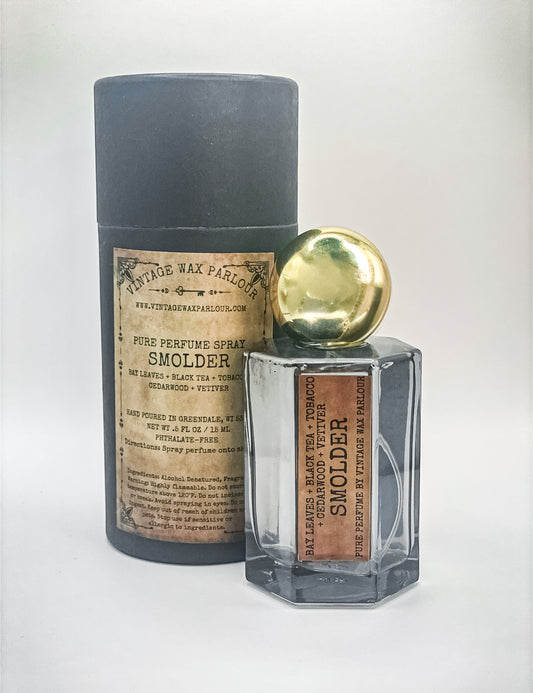 Perfume bottle labeled 'Smolder' with a cylindrical container on a white background