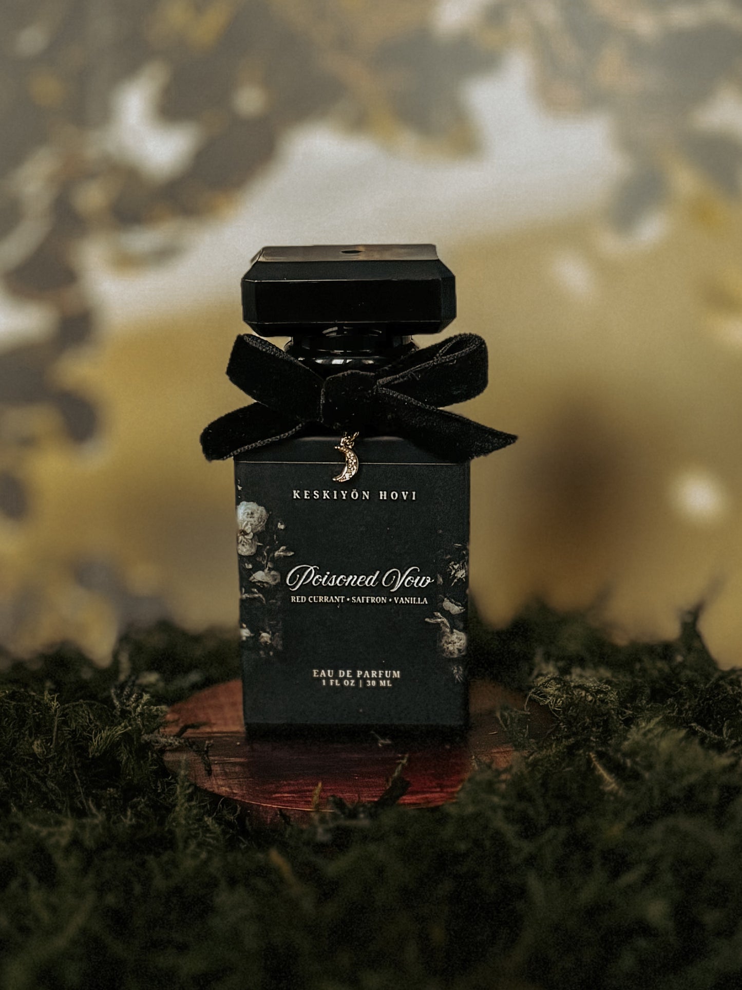 Black perfume bottle with a bow on a reflective surface against a blurred natural background