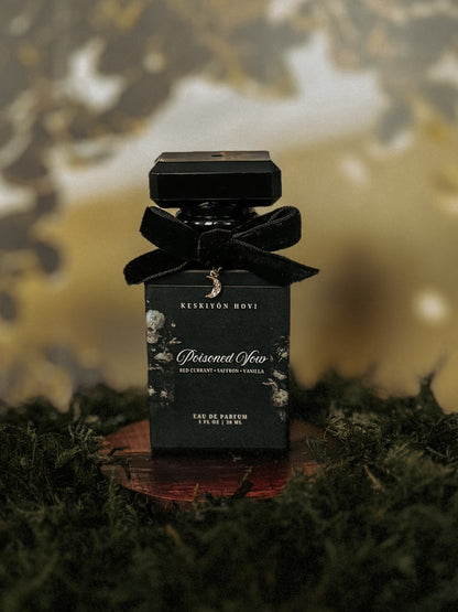 Black perfume bottle with a bow on a reflective surface against a blurred natural background