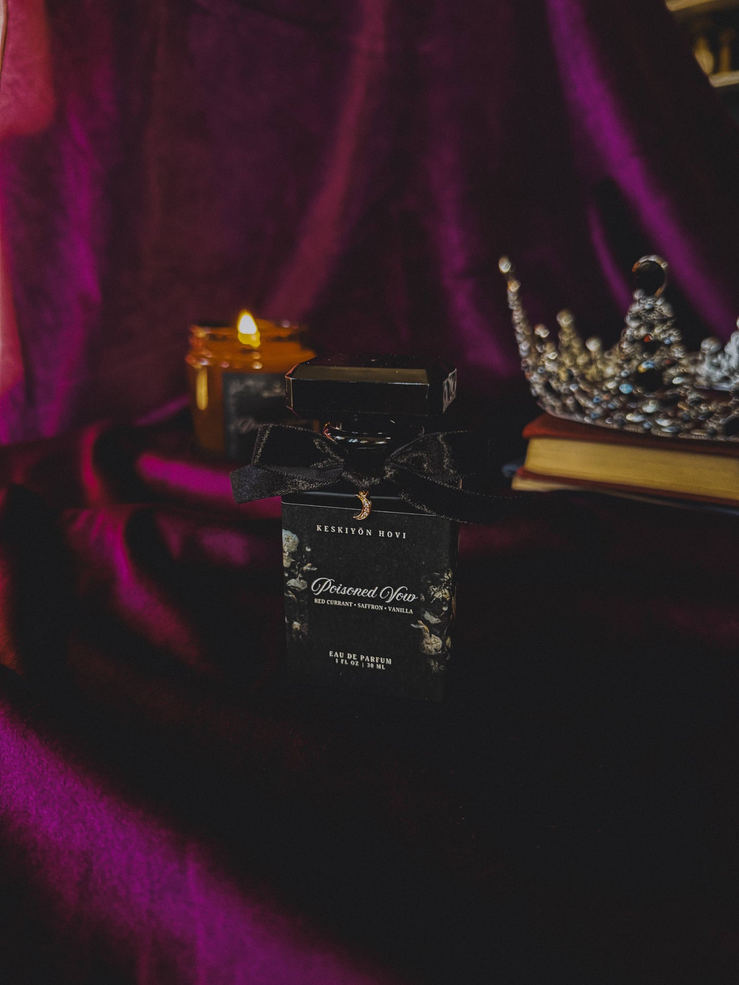 Black perfume bottle with decorative label on a dark surface