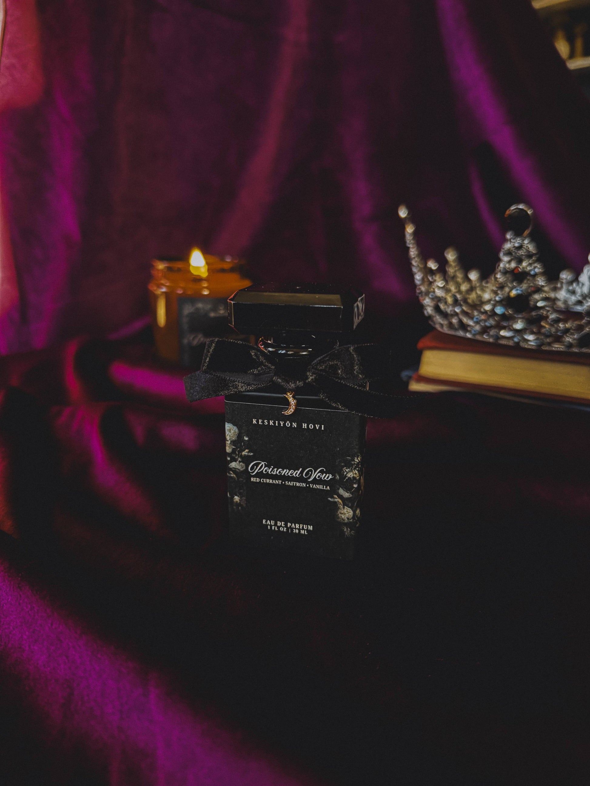 Black perfume bottle with decorative label on a dark surface