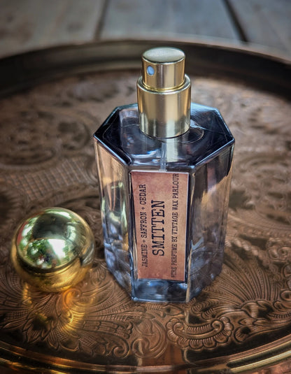 Perfume bottle with gold cap on a decorative metal tray